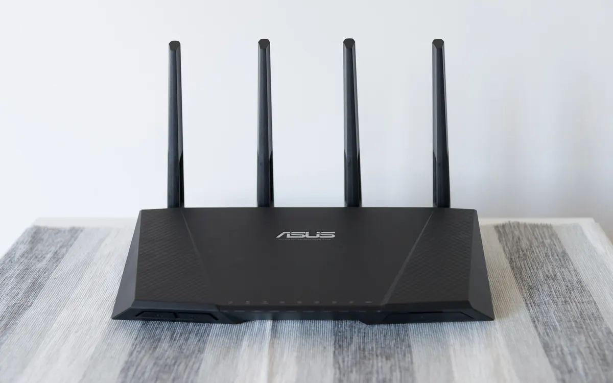 Чорний Wi-Fi-роутер Asus із чотирма антенами на столі (ілюстративне фото, не обов’язково вразлива модель)