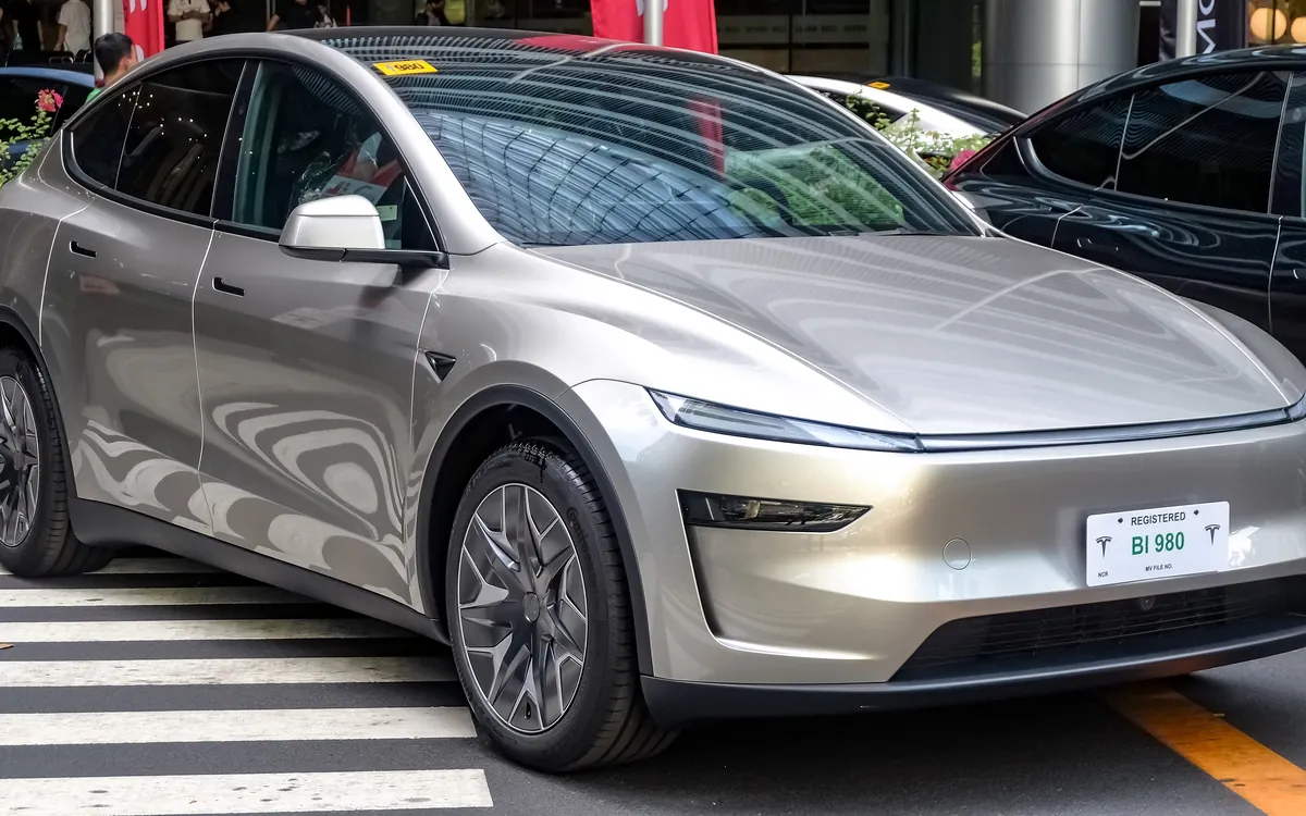 Silver Tesla Model Y L, the long-wheelbase version sold in China, parked at a city crossing