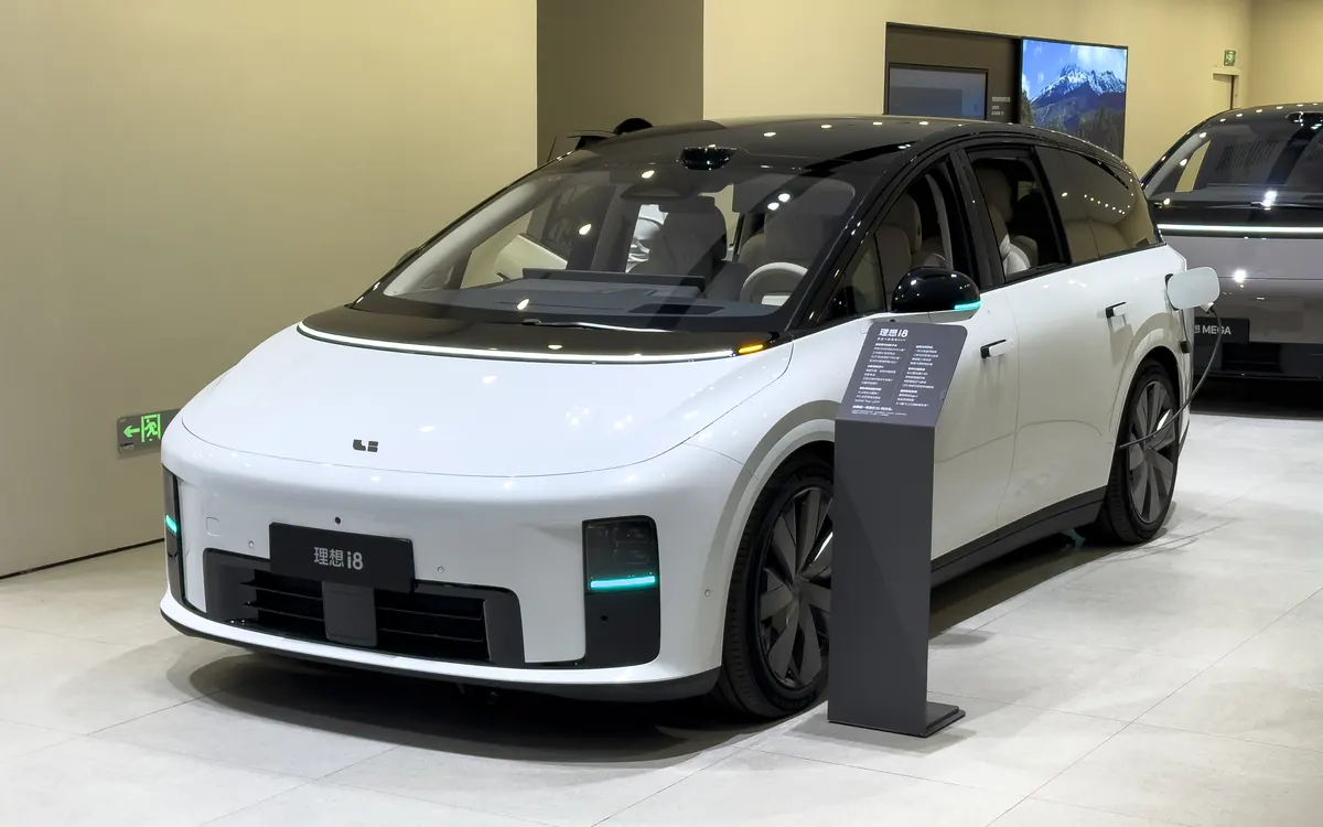 A white Li Auto i8 electric MPV with a roof-mounted lidar sensor on display in a Guangzhou showroom (illustrative photo)