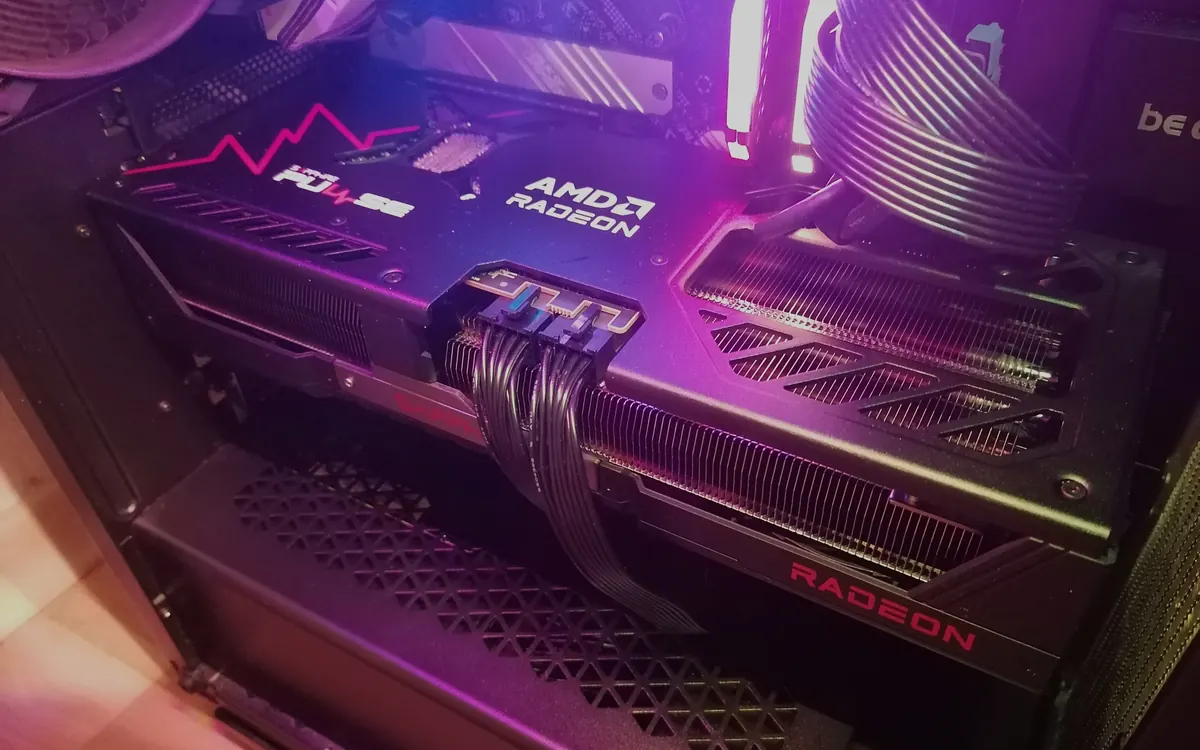 An AMD Radeon RX 9070 XT graphics card installed in a gaming PC with purple lighting (illustrative photo)