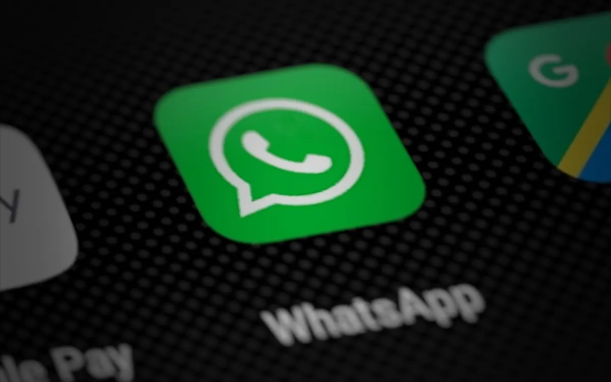 WhatsApp app icon on a smartphone home screen (illustrative photo)