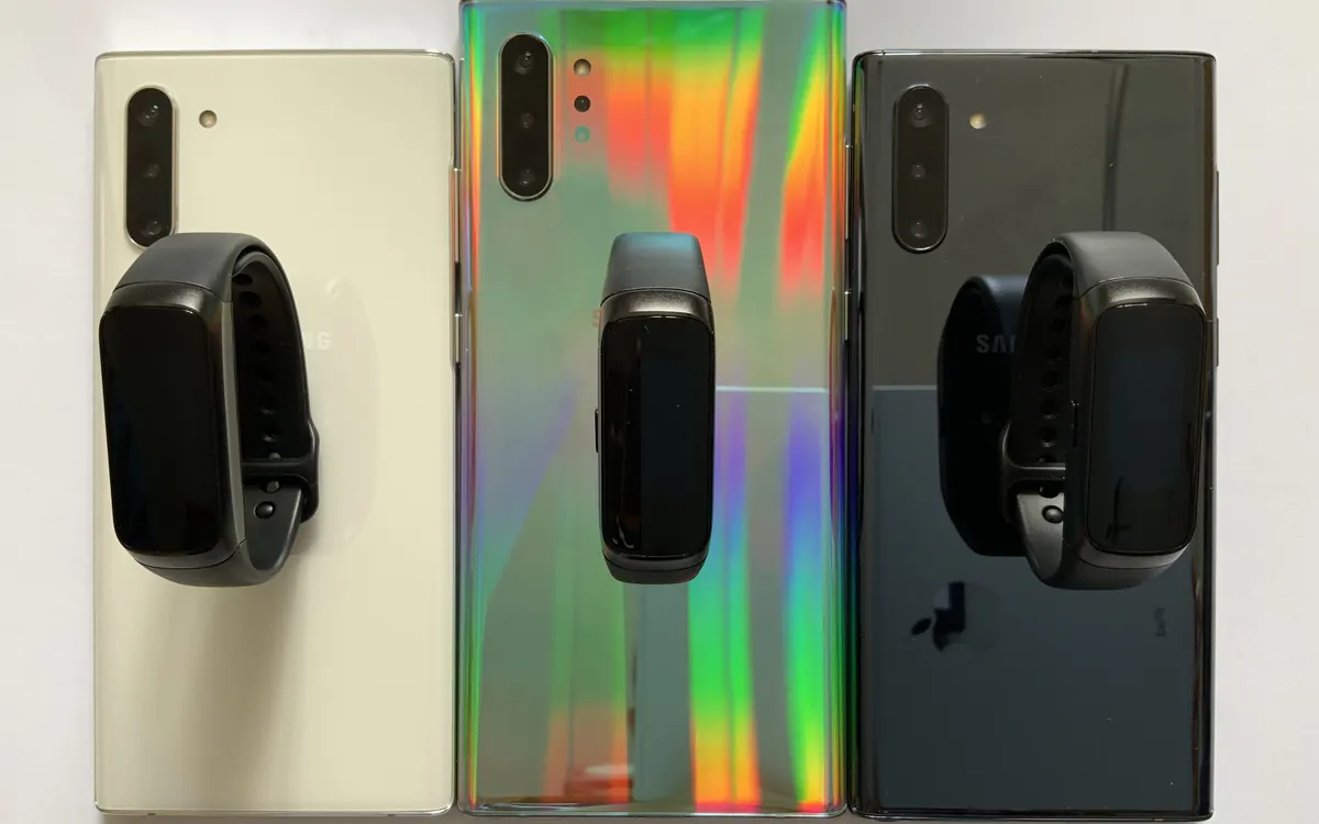 Three Samsung Galaxy Fit fitness bands resting on smartphones (illustrative photo)