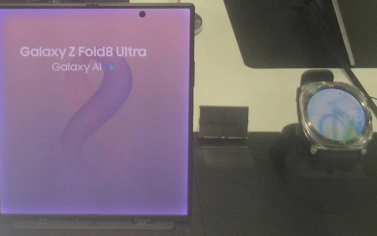 Samsung Galaxy Watch Ultra 2 on a display stand next to a Galaxy Z Fold8 Ultra