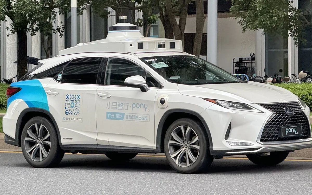 Белое роботакси Pony.ai — Lexus RX с блоком датчиков на крыше — на улице Гуанчжоу (иллюстративное фото, машина прошлого поколения)
