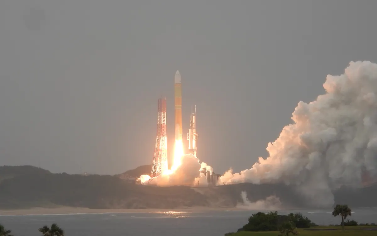 A white H3 rocket climbing from Tanegashima on a column of flame and smoke (illustrative photo of an earlier H3 flight, November 2024, not the MMX launch)