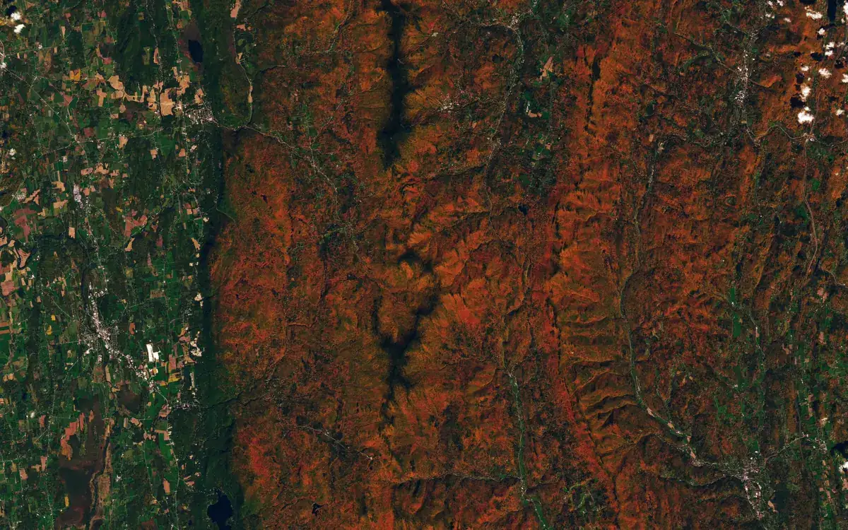 Снимок Landsat 9: красные и оранжевые осенние леса на хребтах центрального Вермонта и зелёные долины рек