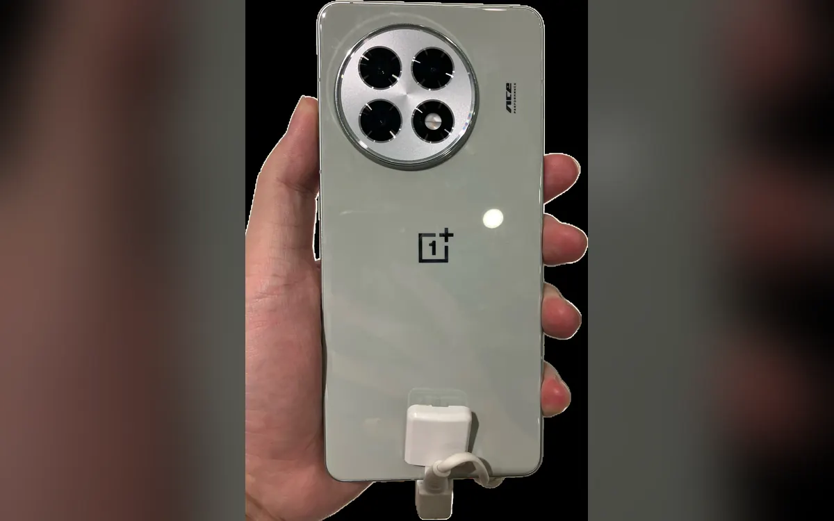 A hand holding a light grey OnePlus Ace 5 with a round camera module, on a blurred background (illustrative photo of an earlier model, not the Ace 7)