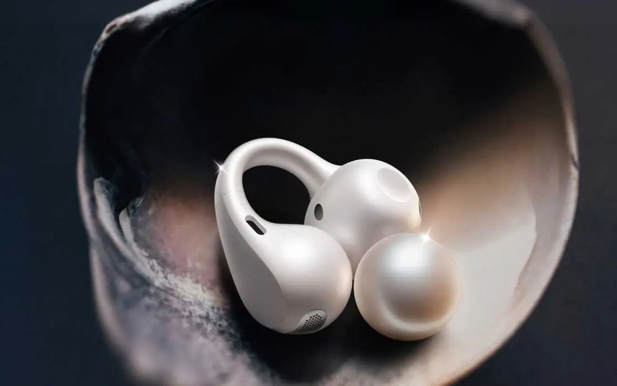 White OnePlus Buds Clip open-ear earbuds resting in a shell-shaped dish
