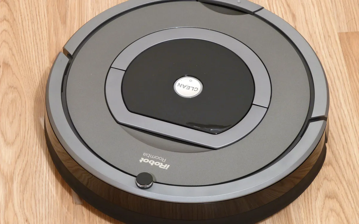An iRobot Roomba robot vacuum on a wooden floor (illustrative photo)