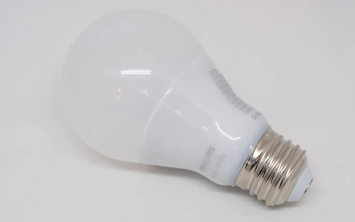 Белая умная LED-лампа Philips Hue с резьбовым цоколем на белой поверхности (иллюстративное фото)