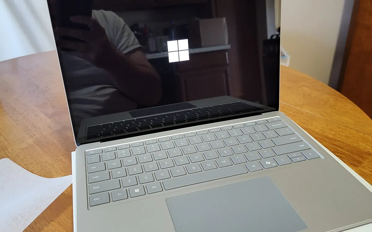 Открытый ноутбук Microsoft Surface Laptop 7 на деревянном столе с логотипом Windows на экране (иллюстративное фото)