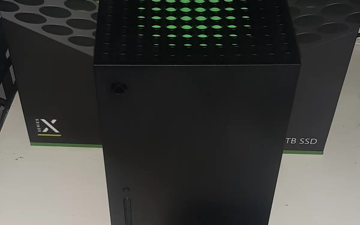 Black Xbox Series X console standing upright next to its retail box